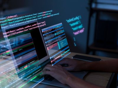 Laptop with multiple screens and code floating above it.